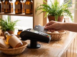 Visa’s Small Merchant Rate Expansion: What It Is Worth to a Health Store Customer tapping a credit card on a payment terminal at a natural health store counter