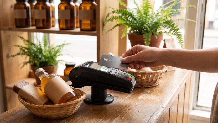 Customer tapping a credit card on a payment terminal at a natural health store counter
