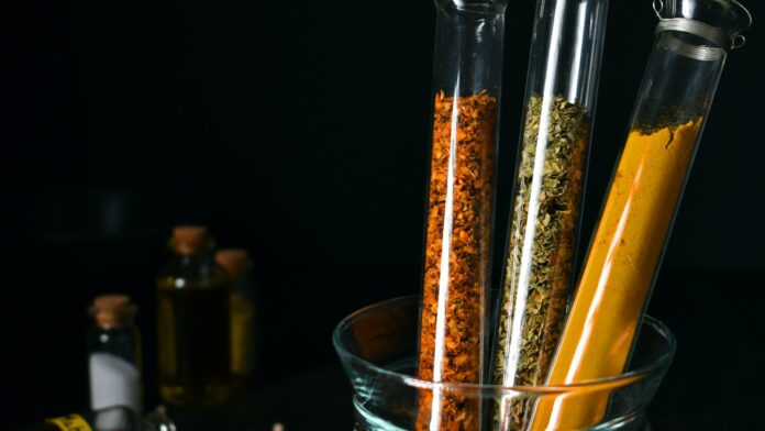 natural-products-for-blood-sugar-hero Turmeric, cinnamon and dried herbs in laboratory test tubes — natural products for blood sugar under the evidence lens
